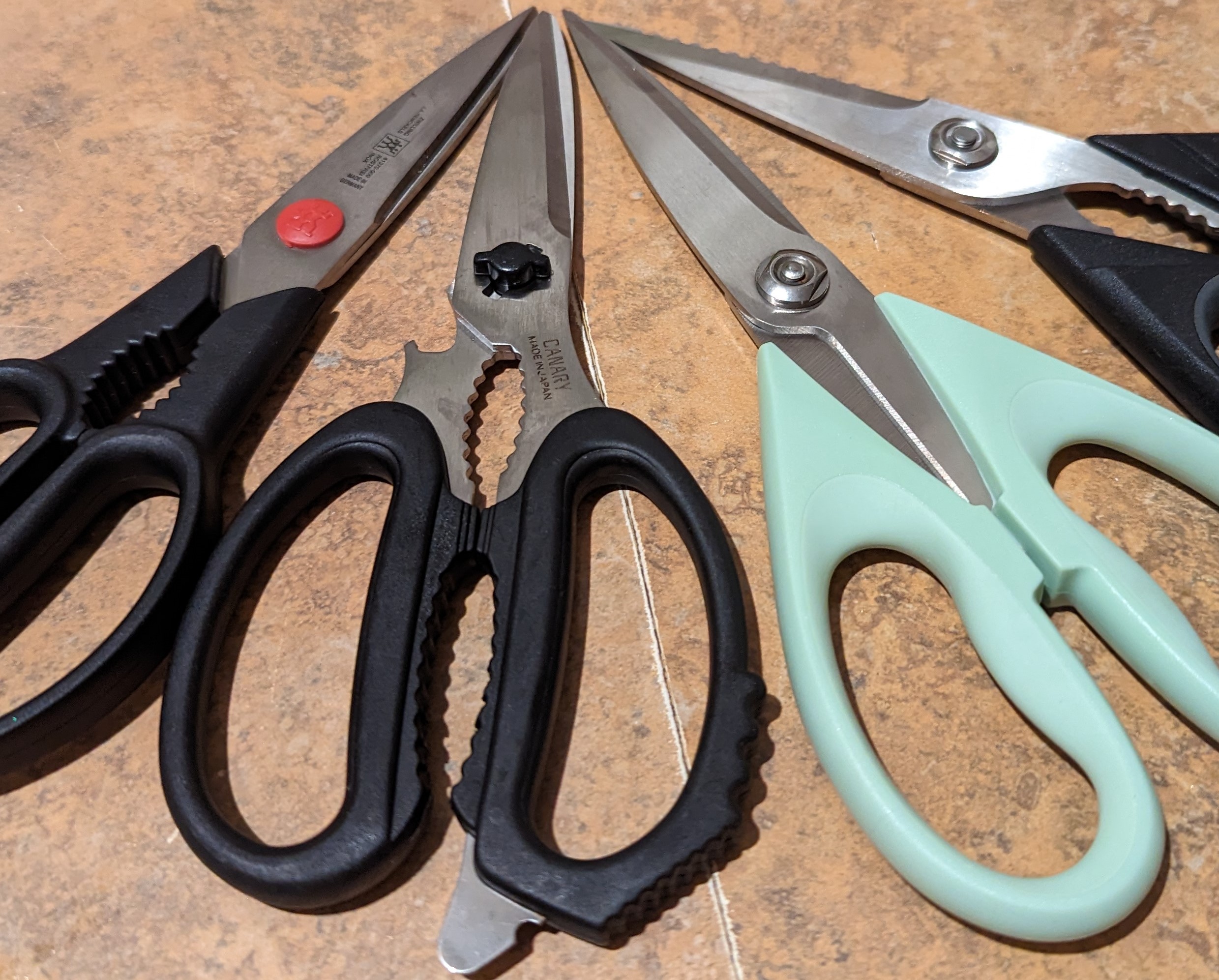 Four scissors on a countertop