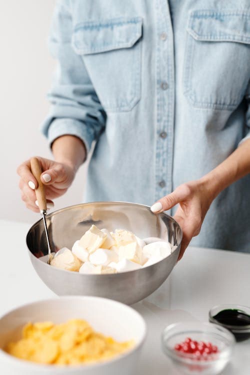 person using stainless steel mixing bowl with ceramic bowl